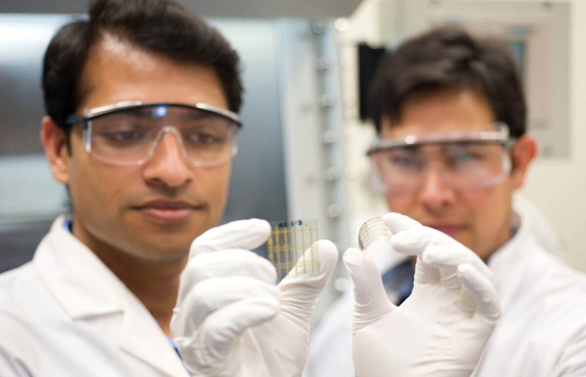 Two male scientists look over a sample together